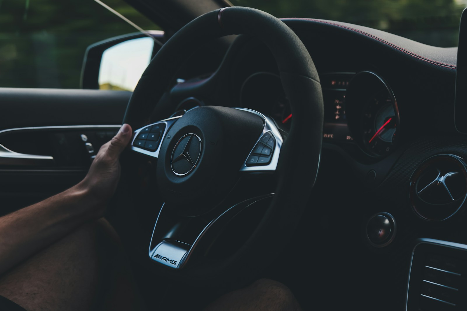 person holding on black steering wheel inside car, auto